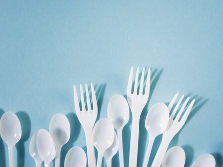 Plastic dishes, disposable tableware, plates, glasses, spoons, forks on a blue background. Caring for the environment. The problem is recycling. Reuse, safe planet, environmental concept. Trash.の写真素材