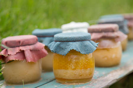 A group of honey in a glass jar, shallow depth of field