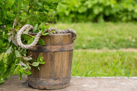 Wooden bucket with rope inside on nature green backgroundの写真素材