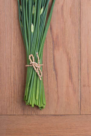Garlic Chives on wood table backgroundの写真素材