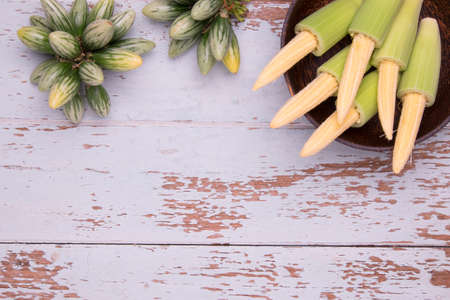 Top View of Baby Corn in the wood bowl and eggplants on wood table backgroundの写真素材