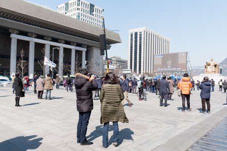 SEOUL, South Korea, March. 10, 2017, People stop walking and watching live broadcast about the judgement of a corruption scandal of the President Park Geun-hye on March 10, 2017 at Gwanghwamun squareのeditorial素材