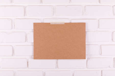 Brown paper taped on white brick wallの写真素材