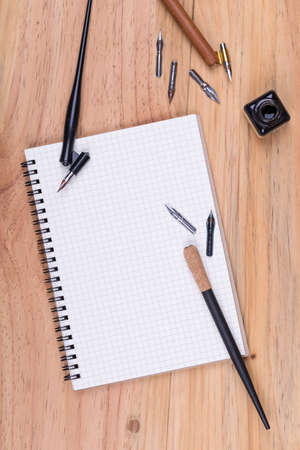 Top view of calligraphy pen with nibs and ink on wooden tableの写真素材