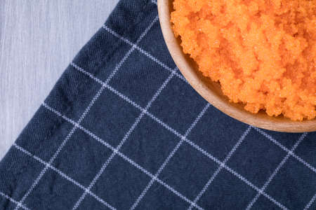Wooden bowl of Tobiko (Flying fish caviar) on navy plaid naperyの写真素材
