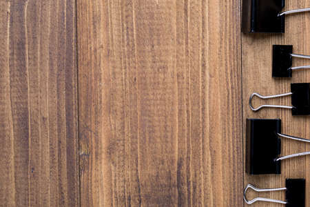 Top view of Black clip in pattern on dark wooden background