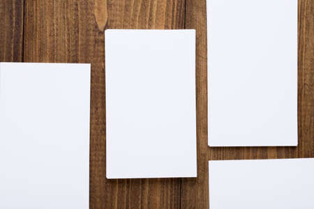 Top view of white business cards in pattern on dark wooden background, use for mock up branding identityの写真素材