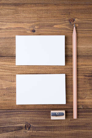 Top view of stack white business cards with pencil and shapener on dark wooden background, use for mock up branding identityの写真素材