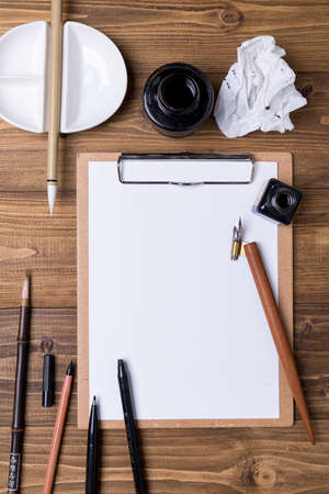 Top view of Calligraphy mediums (pen, ink, brush) on wooden backgroundの写真素材