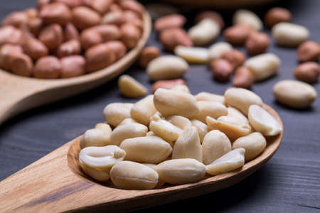 Peeled Peanuts on dark wooden table, selective focusの写真素材