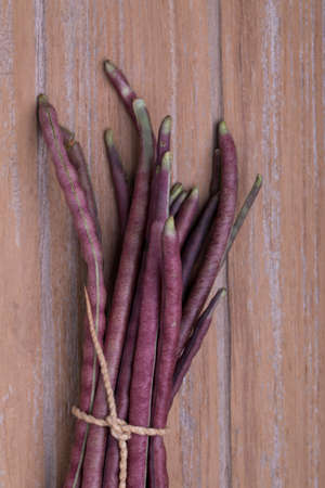 Purple Cowpea (Purple Yardlong Bean) on wooden background, top viewの写真素材