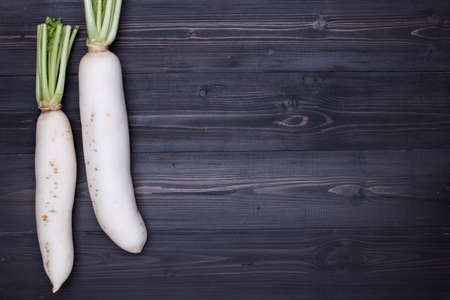 White Radish on dark wooden background top view with copy spaceの写真素材
