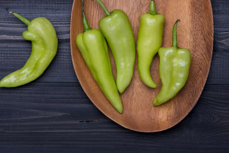 Green Peppers on dark wooden background, top viewの写真素材