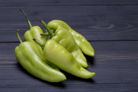 Green Peppers on dark wooden background, selective focusの写真素材