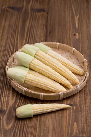 Fresh baby corn on wooden background, selective focusの写真素材