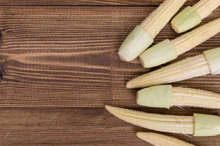 Top view of Fresh baby corn on wooden backgroundの写真素材