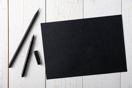 Set of Blank black paper, black pen and black pencil on white wooden background, copy space, templateの写真素材