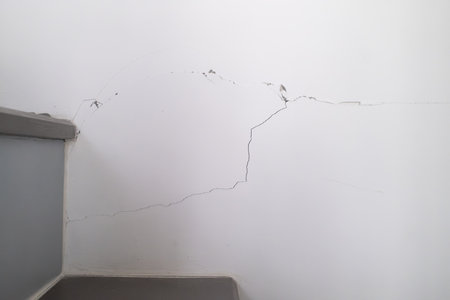 Cracked white wall in a room. Damaged white wall from Earthquake in Condominium, Bangkok Thailandの写真素材