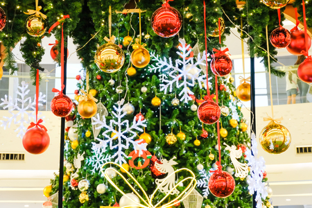 Many colorful christmas ball hang by ribbin with fake christmas tree for background (Selective Focus)の写真素材