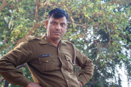 AGRA, INDIA - DECEMBER 2012: Indian police officer smiling looking at camera on a river bankのeditorial素材