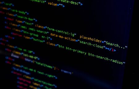 The screen of the program source code on the laptop placed on the desk, which the programmer has developed into a website or mobile app, as system analysis and designer designedの写真素材