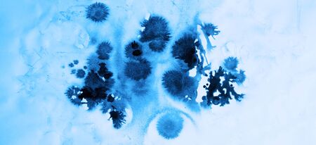 Watercolor droplets on a wet white paper background, blue tone backgroundの写真素材