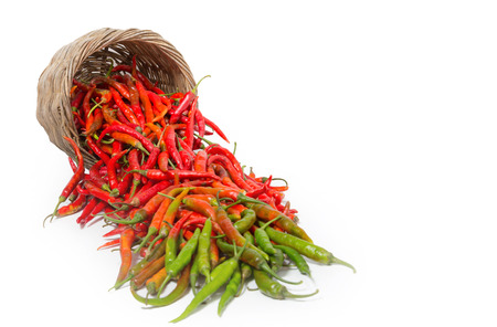 Colorful chilli with the basket on white backgroundの写真素材