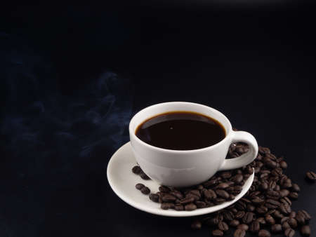 A cup of hot black coffee on black background with hot steamの写真素材