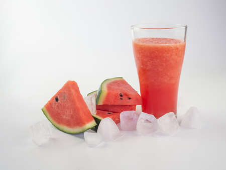 Watermelon smoothie with watermelon slices and ice cube on white backgroundの写真素材