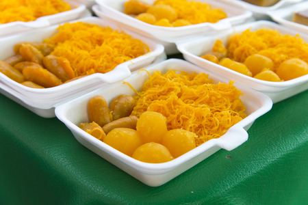 egg yoke fudge balls cooked in syrup, thai dessert in foam package on display dessert shop, in street bangkok marketの写真素材