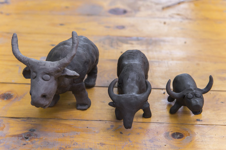 buffalo clay sculpture on wooden background in outdoorの写真素材