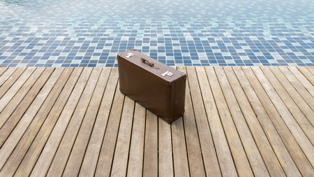 vintage leather luggage on wooden walkway swimming pool resortの写真素材