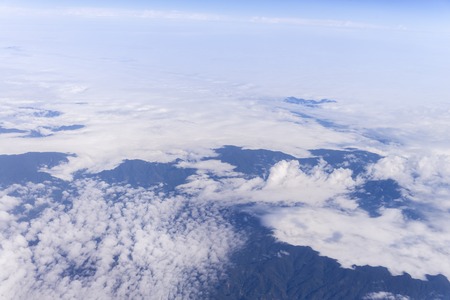 Blue sky with clouds background, view from the window of an airplane flyingの写真素材
