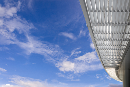 Corridor with modern office building roof with blue sky and white clouds backgroundの写真素材