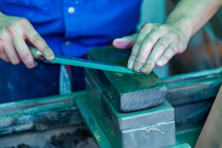 Sharpening a knife with a whetstoneの写真素材
