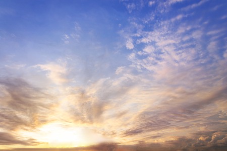 sunset / sun rise sky with rays of yellow and red light shining clouds and sky background and textureの写真素材