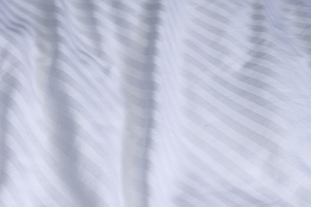 Top view of white bedding striped textile, Elegant textile on bed