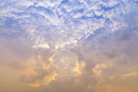 sunset / sun rise sky with rays of yellow and red light shining clouds and sky background and textureの写真素材