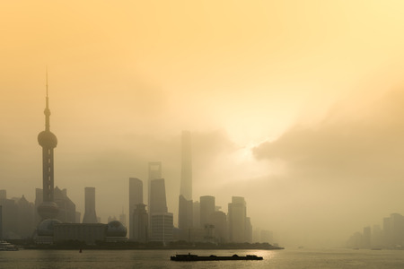 Shanghai Financial Center and modern skyscraper city in misty gold lighting sunrise behind pollution haze, view from the bund in Shanghai, China. vintage picture styleの写真素材