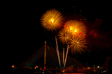 Beautiful yellow and red color firework display for celebration happy new year and merry christmas in the night sky, bangkok city, thailandの写真素材