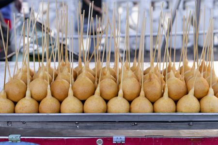 Deep fried snack of Thai traditional snack made from stickyrice flour, rice flour and stuff with sausage, on 
mobile street food shop in bangkok, thailandの写真素材