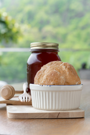 Strawberry jam in jar and fresh homemade bread on wood backgroundの写真素材