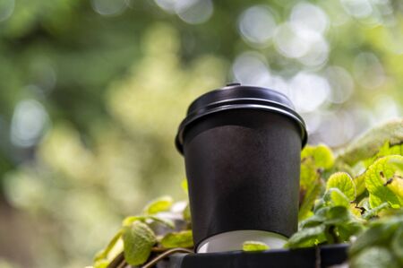 paper coffee cup with green outdoor backgroundの写真素材