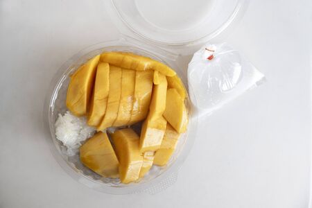 Thai sticky rice and coconut milk with mango in plastic boxの写真素材