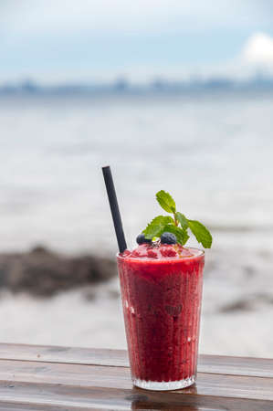 Fresh Blueberry smoothies  in glass  on wood table with outdoor backgroundの写真素材