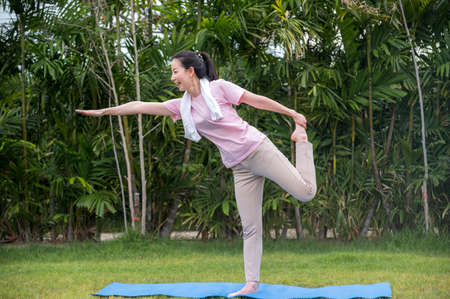 Asian Beauty and healthy woman exercise and doing meditation of yoga on exercise mat in the outdoor park -  fitness, sport , yoka concept.の写真素材