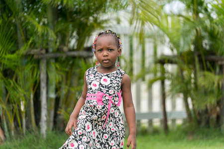 portrait of cute young african girl playing in outdoor garden.の写真素材