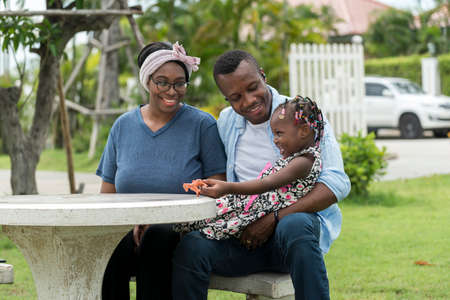 Happy African family play with daughter in family relax in outdoor garden.の写真素材
