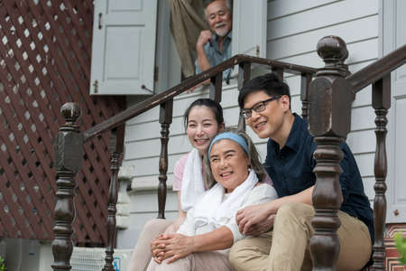 Asian young woman and man hug and take care senior parent grandmom with happy smile on outdoor...