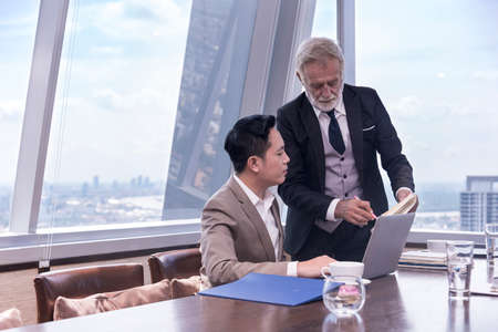 businessman guilding staff for business deal at skyscraper office lounge with cityscape business zone backgroundの写真素材